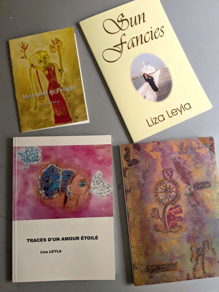 Four books by Liza Leyla are lying on a grey surface. Three feature paintings by the writer. One features a photo of the writer.