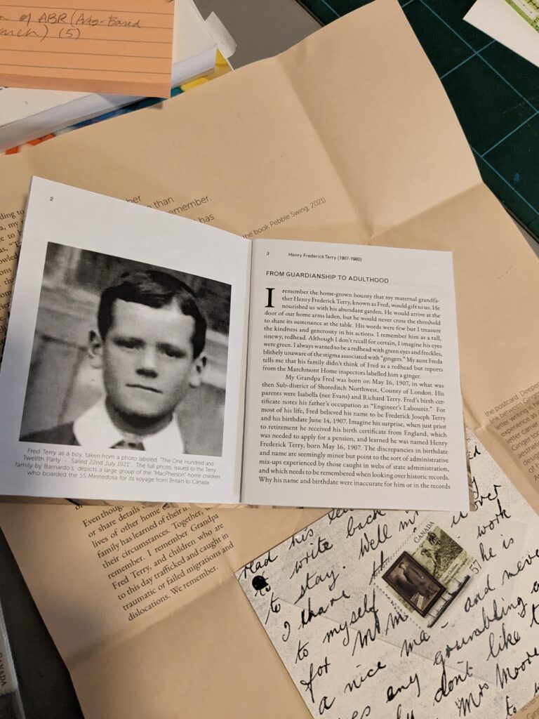 Pieces of the artist book are seen, including a spread of the booklet with the face of a 14 year old Fred Terry in black and white. He has a fresh hair cut and his white collared shirt is just visible in the frame.