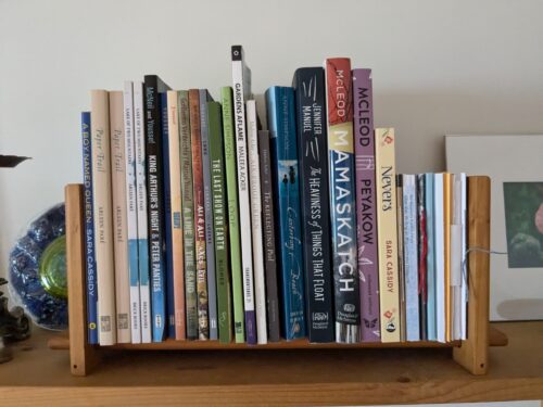 A small wooden shelf holds about 20 poetry chapbooks and memoirs.