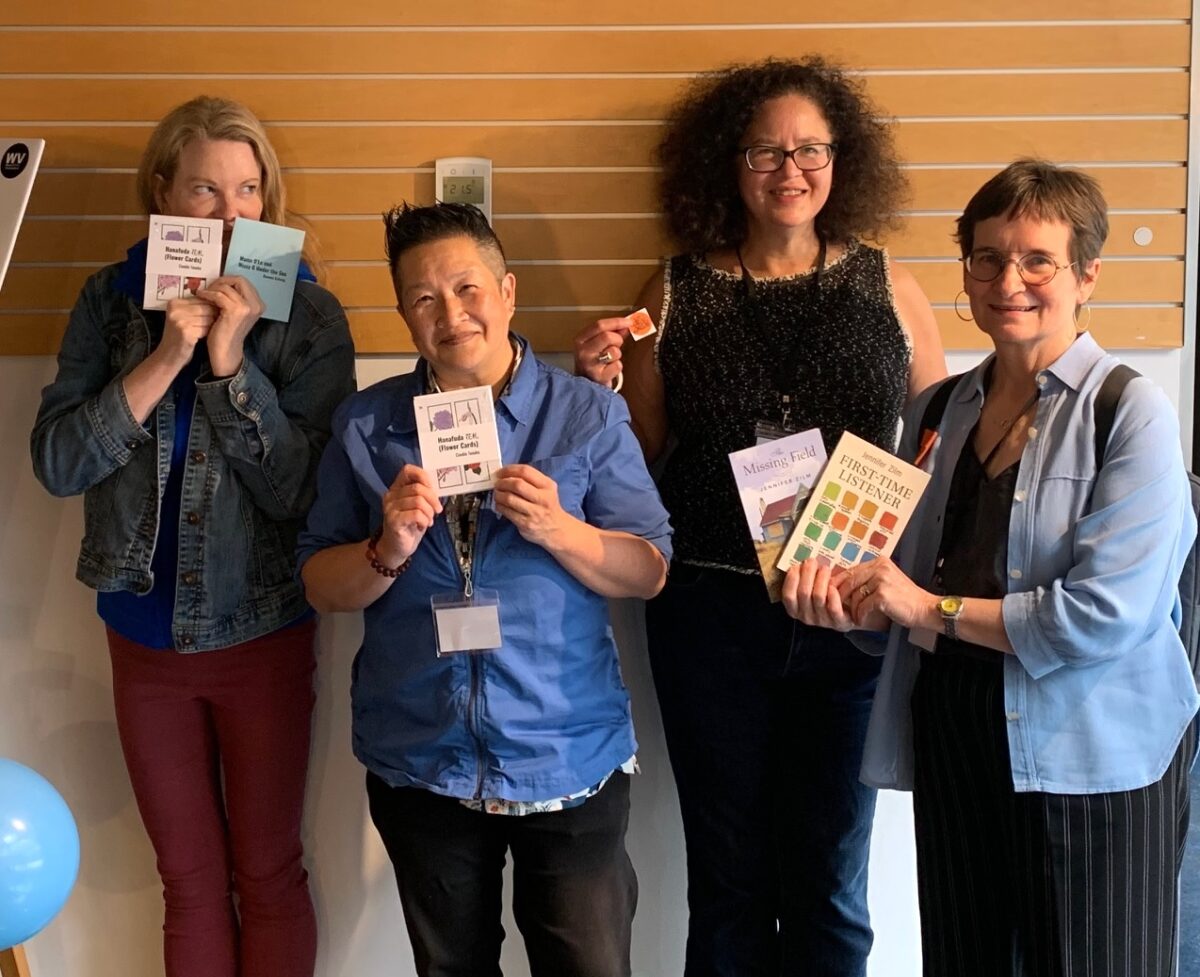 ennifer Zilm, Candie Tanaka, Deanne Achong, Lois Klassen show exchanged items. Jennifer is holding Hanafuda (Flower Cards) and Mama D'Lo and Missy G Under the Sea, Candie is holding Hanafuda (Flower Cards) and Lois is holding two of Jennifer's books, The Missing Field and First-Time Listener.