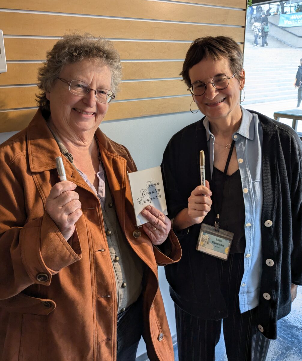 Lorna Boschman and Lois Klassen are seen with exchanged items: a gold marker and the book Train Country Emigrant by Sarah Klassen